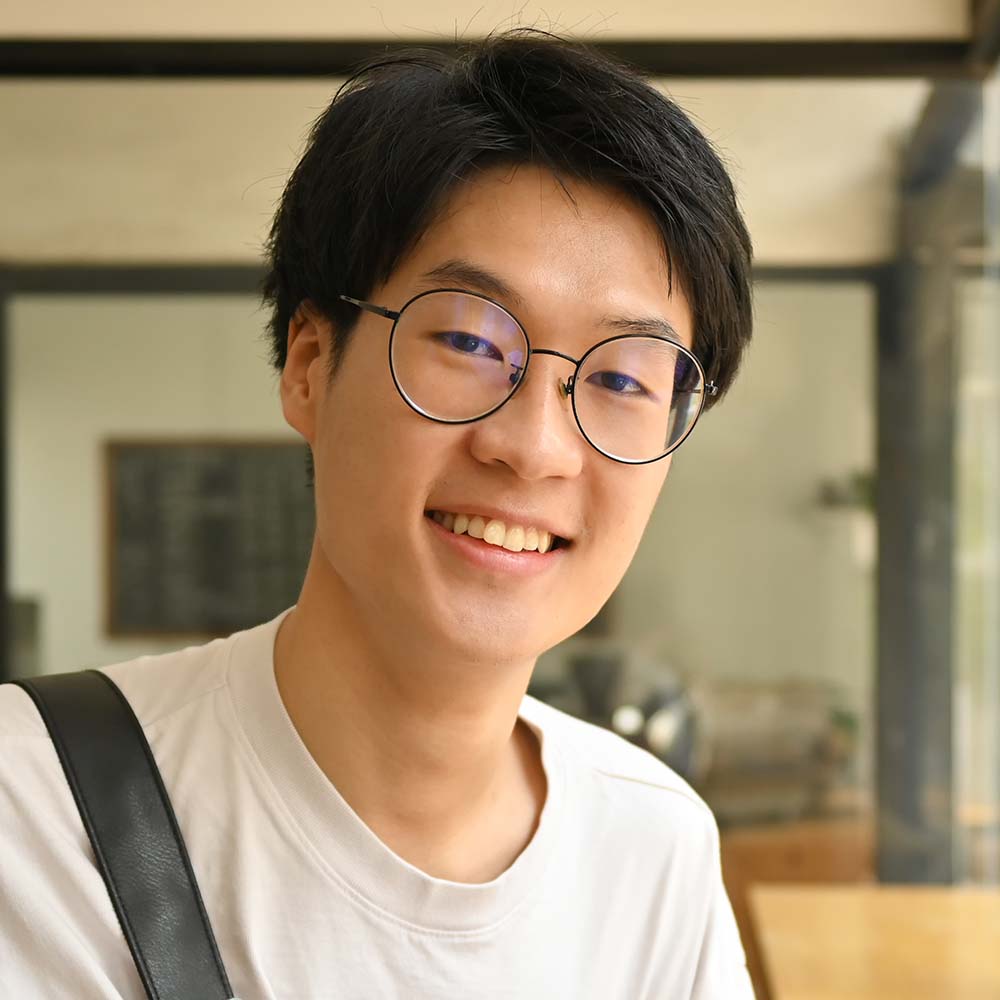 Asian male university student in glasses holding books and smiling to camera. Education, school, college concept.